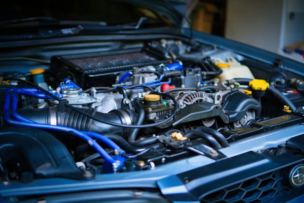 Engine bay of a car with blue hoses and a top-mounted intercooler